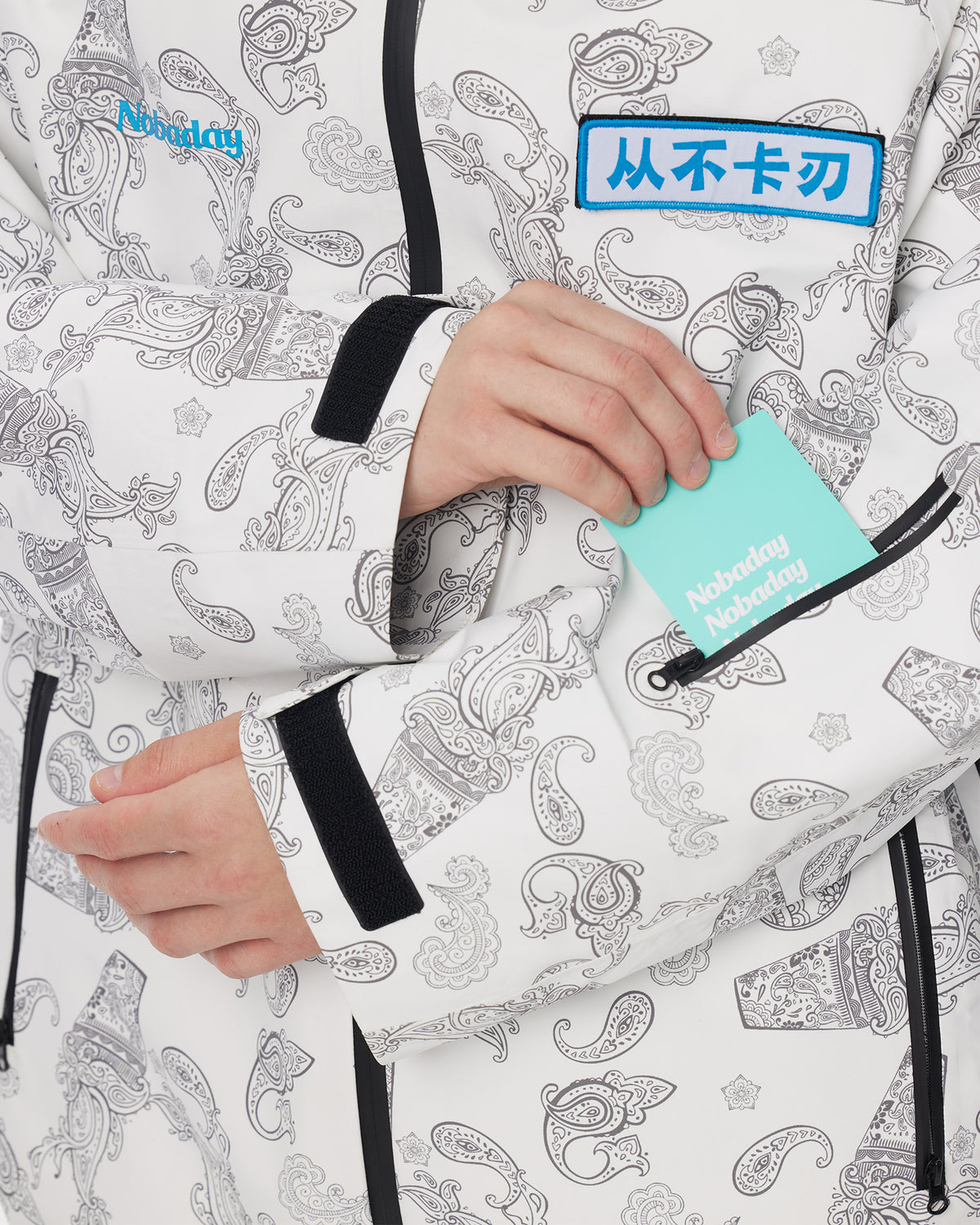 Close-up of the sleeve ski pass pocket and adjustable cuff on the Nobaday Dawn Print 3L Zip-Up Snow Jacket