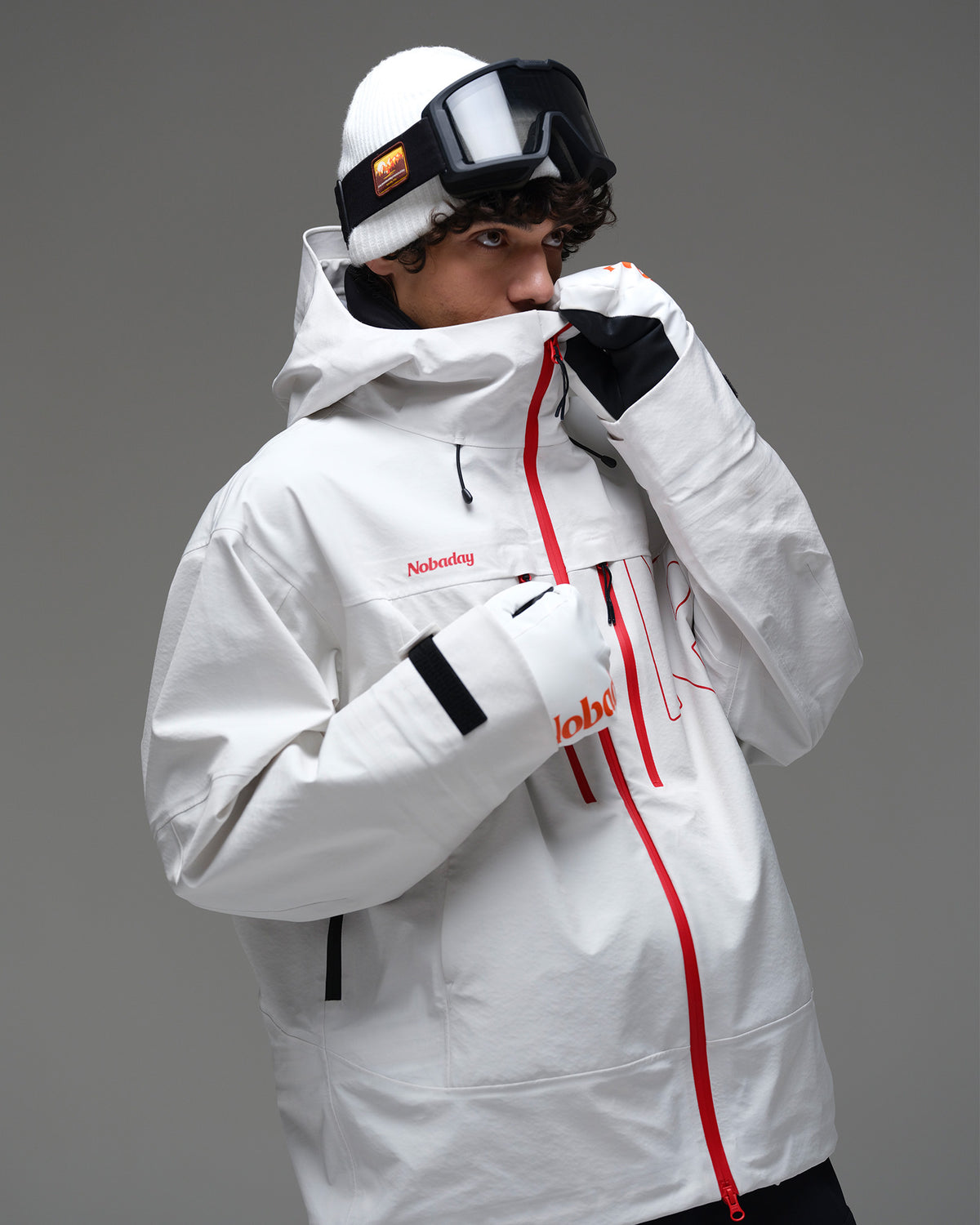 Upper-body view of the white NOBADAY Apex 3L snow jacket with red zippers and an adjustable hood