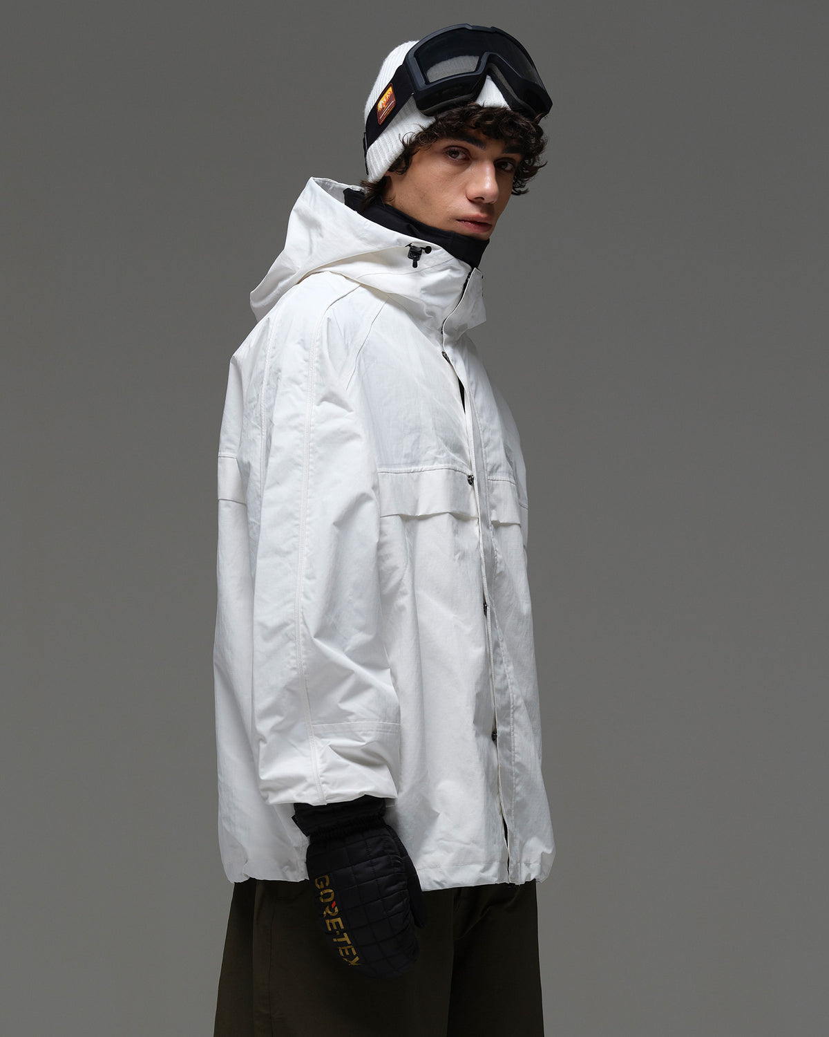 Side view of a man wearing the white NOBADAY Pure Free snow jacket with a high collar