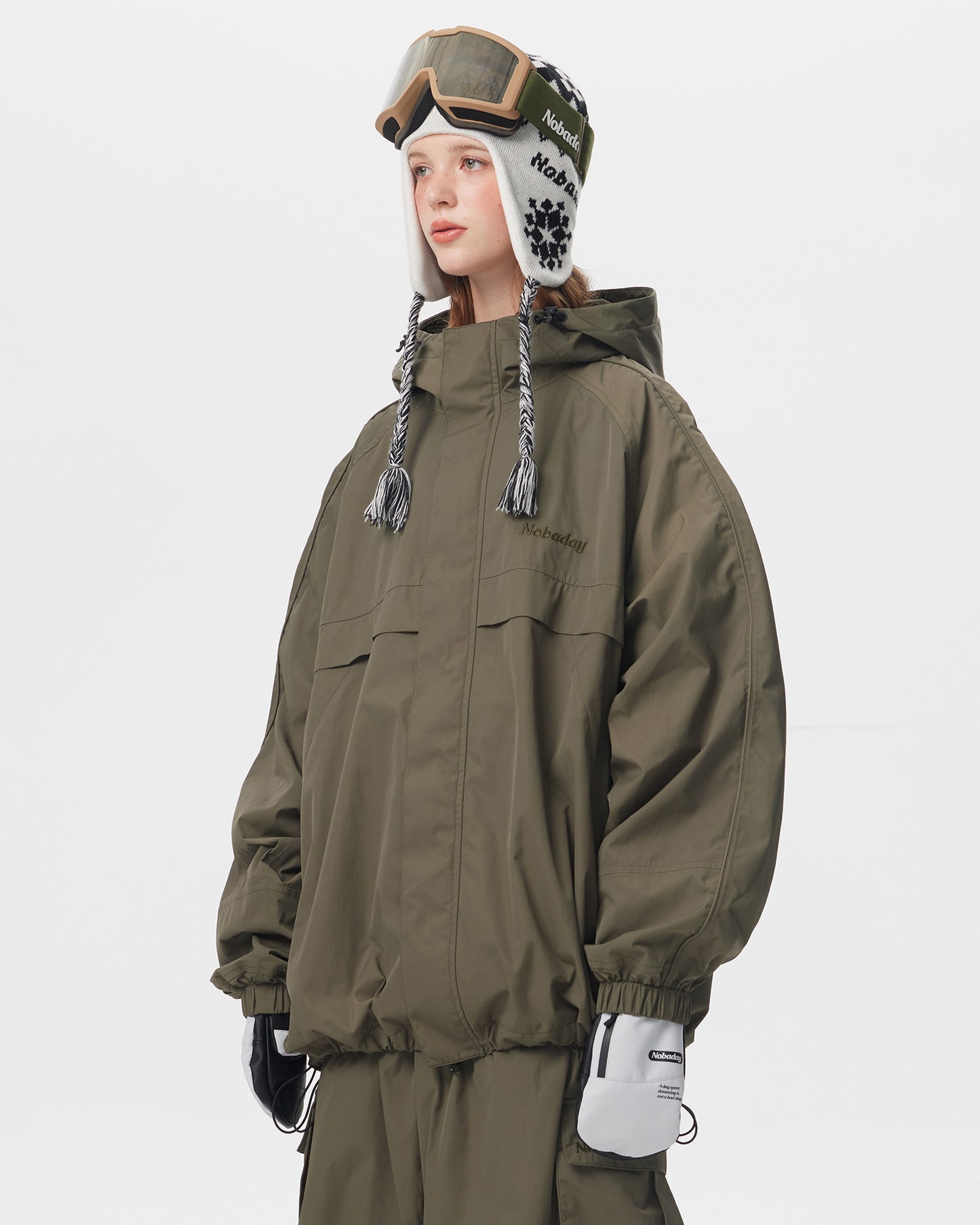 Side view of Nobaday women's green snow jacket with oversized hood, high collar, elastic cuffs, and relaxed snowboard fit