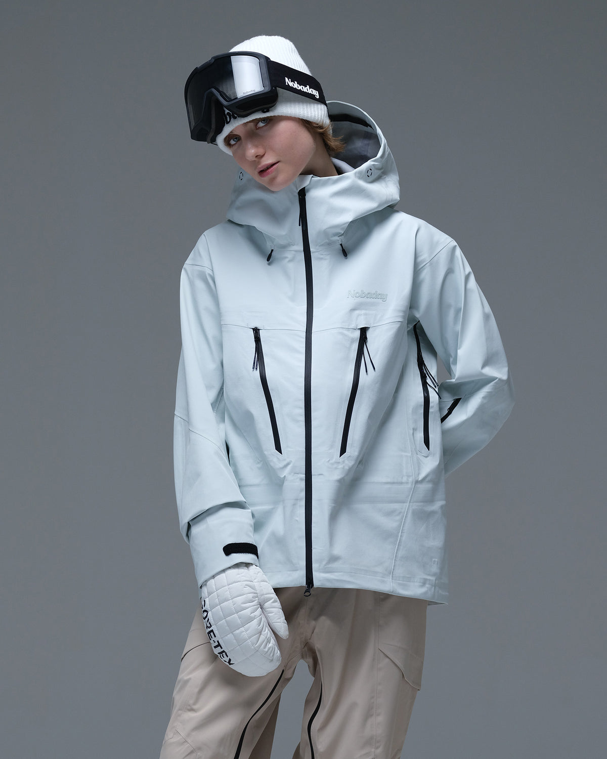 Half-body action view of a model wearing the ice blue Nobaday Women’s Snowshield Pro 3L Snow Jacket with black waterproof zippers