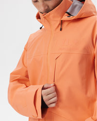 Close-up of the waterproof chest zipper pocket and Nobaday Care logo on the ArcticStorm Freeride Orange 3L Snow Jacket