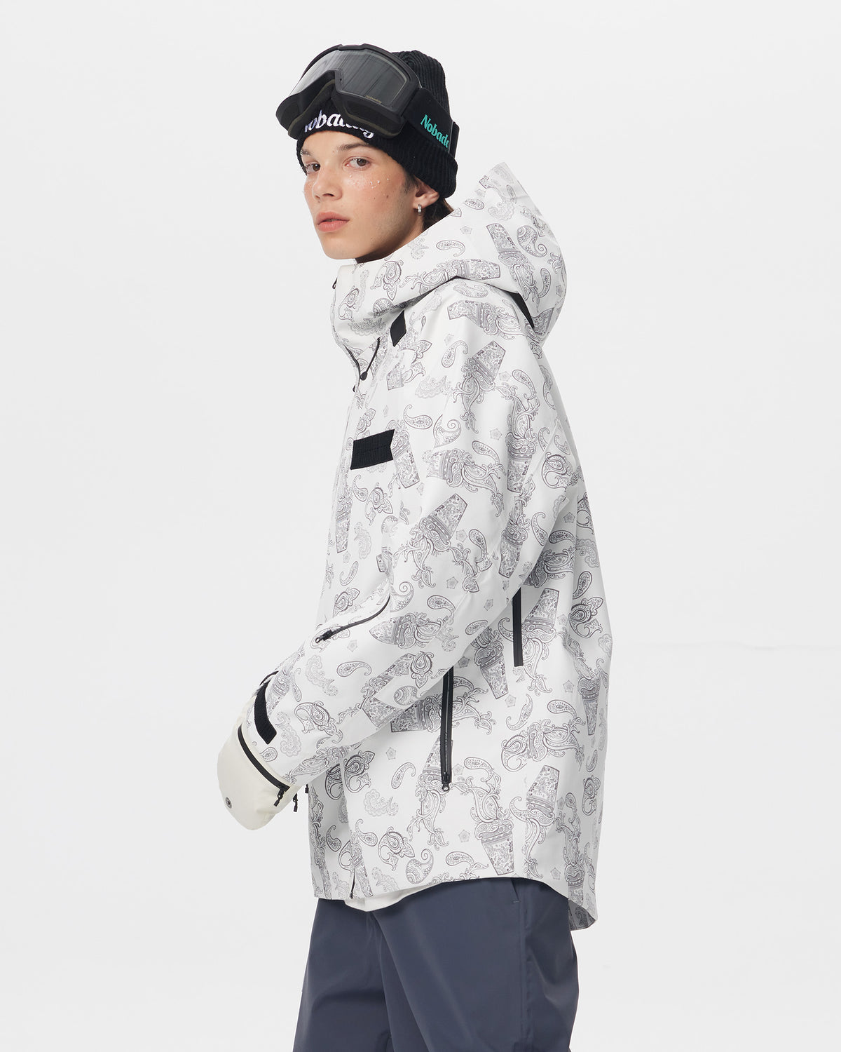 Side view of a model wearing the white paisley-print Nobaday Dawn Print 3L Zip-Up Snow Jacket