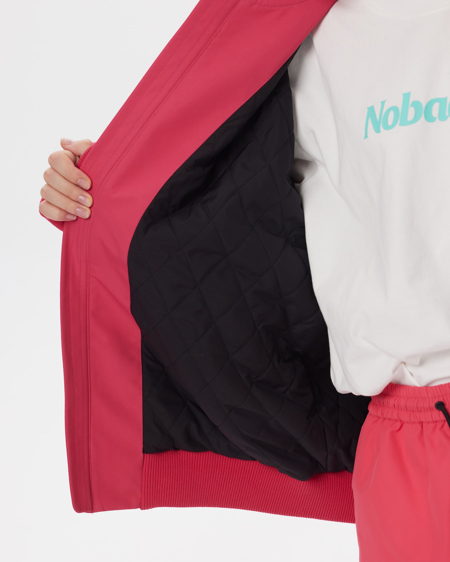 Interior close-up of the Nobaday Juicy Dark Red Jacket showing its black quilted insulation and ribbed hem