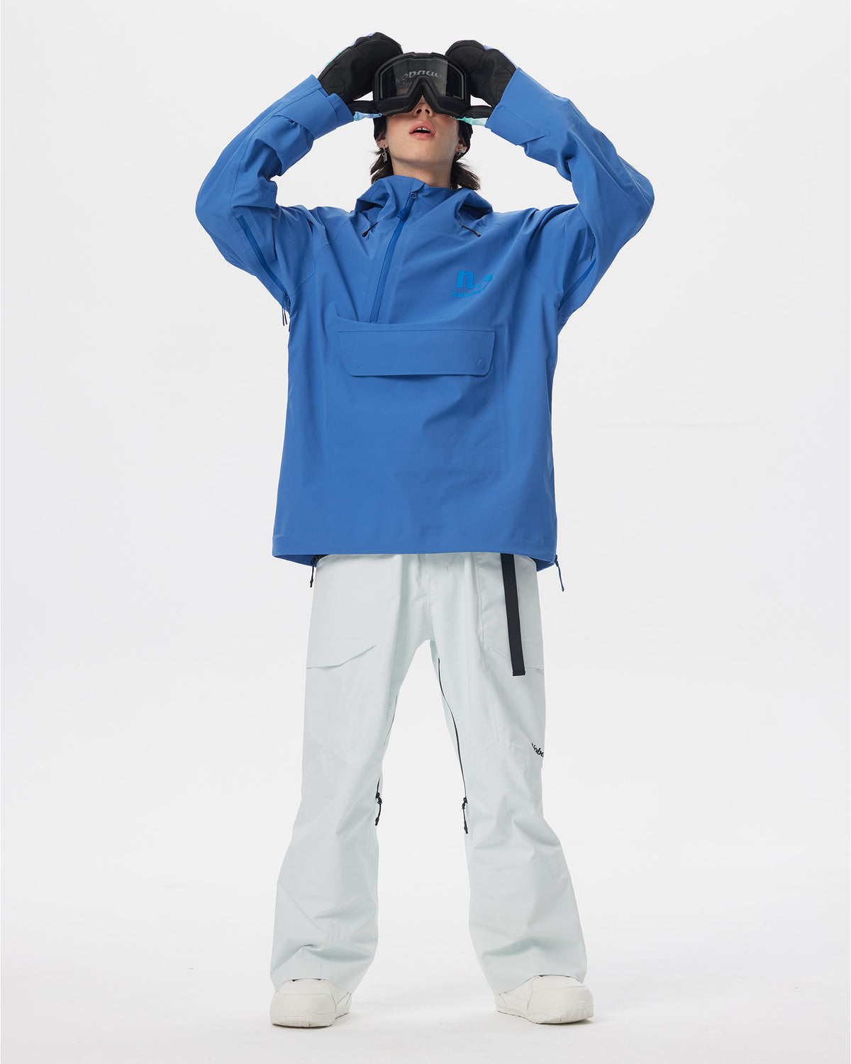 Full-body action view of a male model wearing the blue Nobaday Men’s ArcticStorm 3L Anorak Snow Jacket and adjusting his goggles