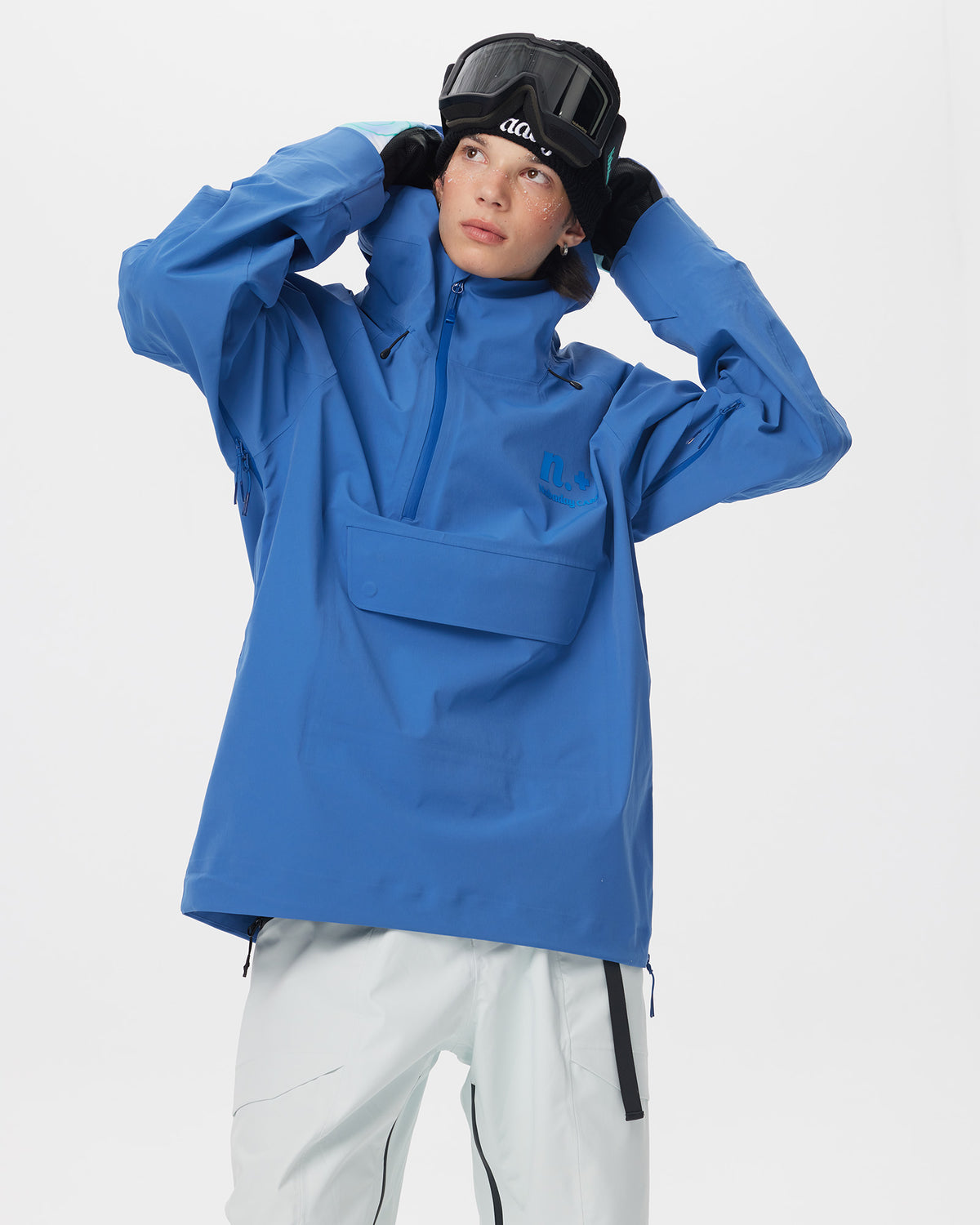 Male model wearing the Nobaday Men’s ArcticStorm 3L Anorak Snow Jacket in blue, adjusting his goggles in a half-body action pose