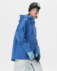 Side view of a male model wearing the Nobaday Men’s ArcticStorm 3L Anorak Snow Jacket in blue with white snow pants