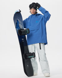 Male model wearing the blue Nobaday Men’s ArcticStorm 3L Anorak Snow Jacket with white snow pants while holding a snowboard