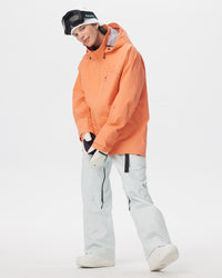 Full-body lifestyle view of a male model wearing the Nobaday ArcticStorm Freeride Orange 3L Snow Jacket and white snow pants