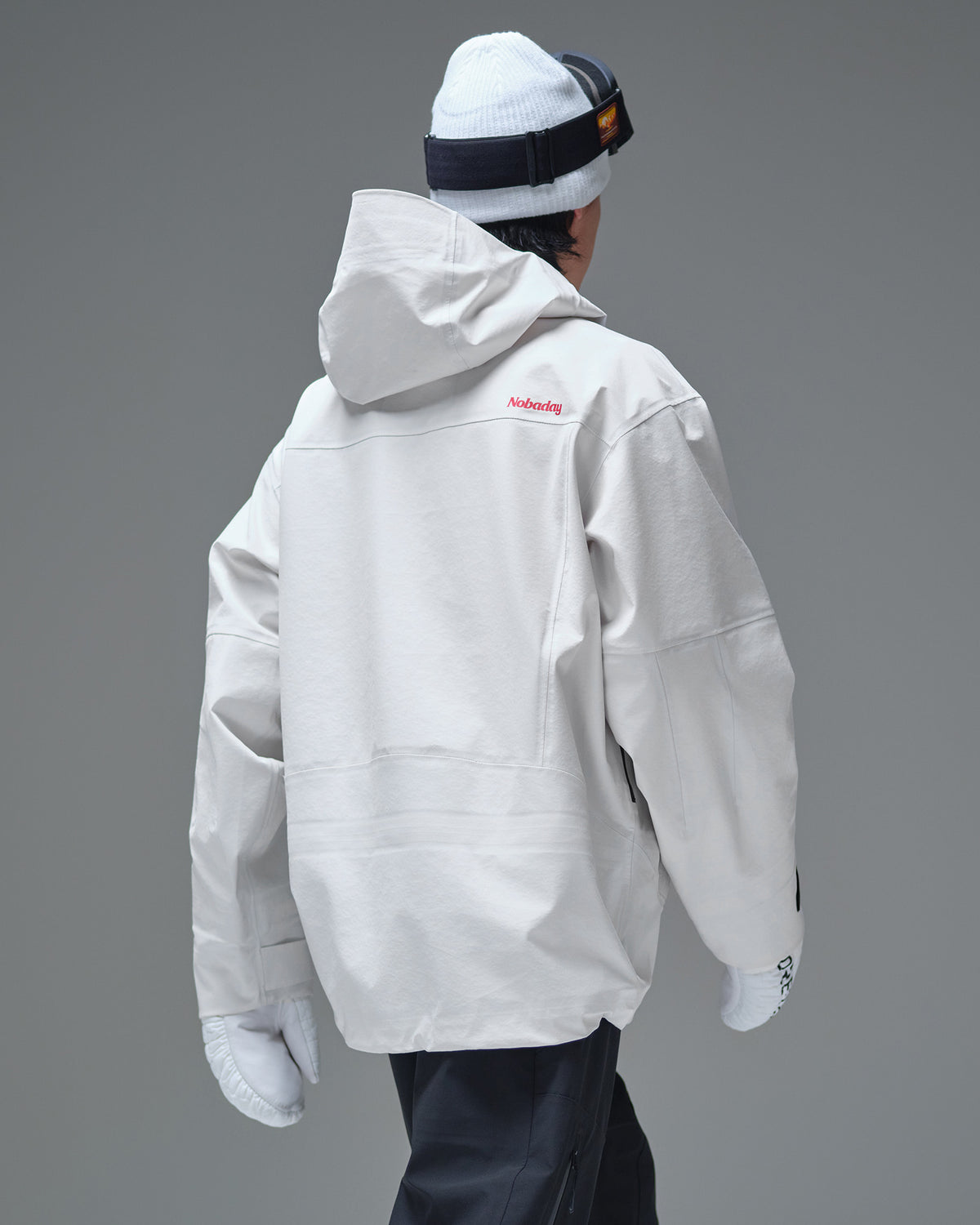 Back view of the white NOBADAY Pure Free Apex 3L snow jacket with a hood and red logo