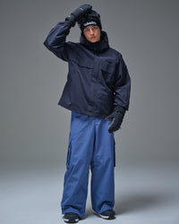 Man wearing a black NOBADAY Pure Free snow jacket with blue snowboard pants