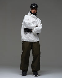 Full-body front view of a man wearing a white NOBADAY Pure Free snow jacket and dark snow pants