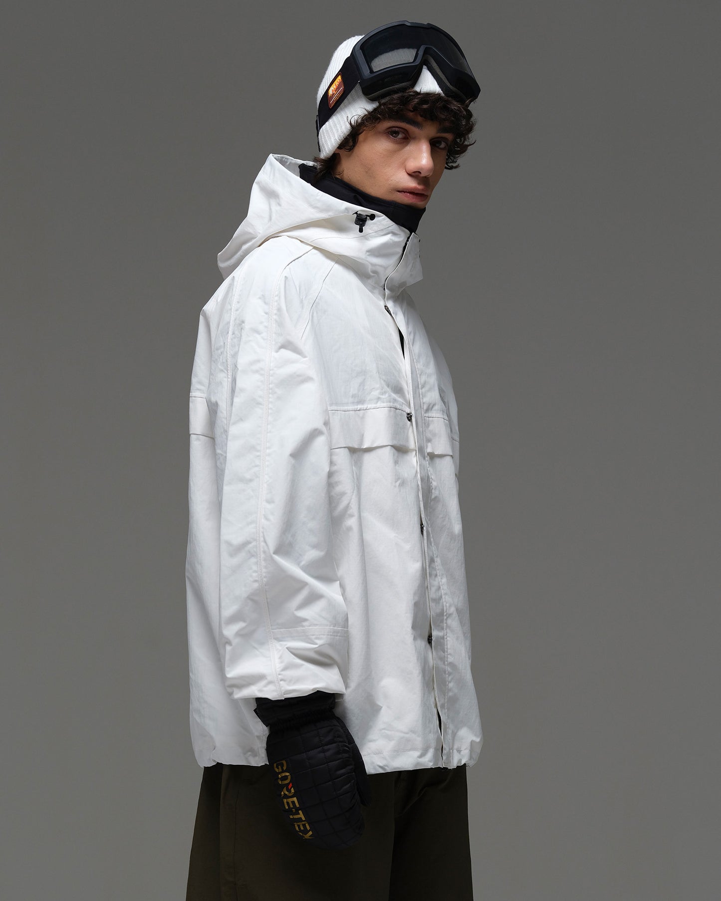 Side view of a man wearing the white NOBADAY Pure Free snow jacket with a high collar