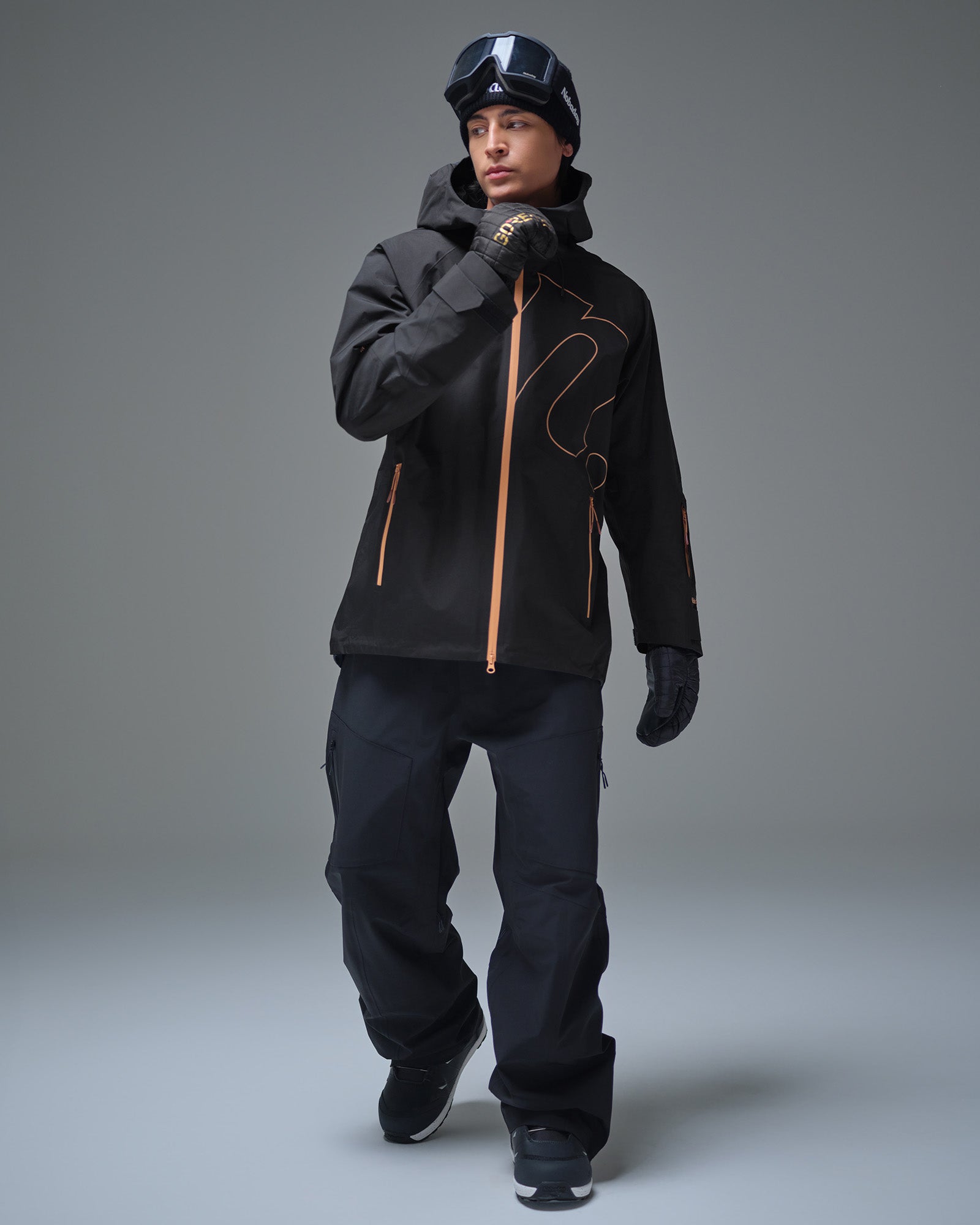 Full-body view of a man wearing the Black NOBADAY Men’s Summit GORE-TEX snow jacket with black snow pants