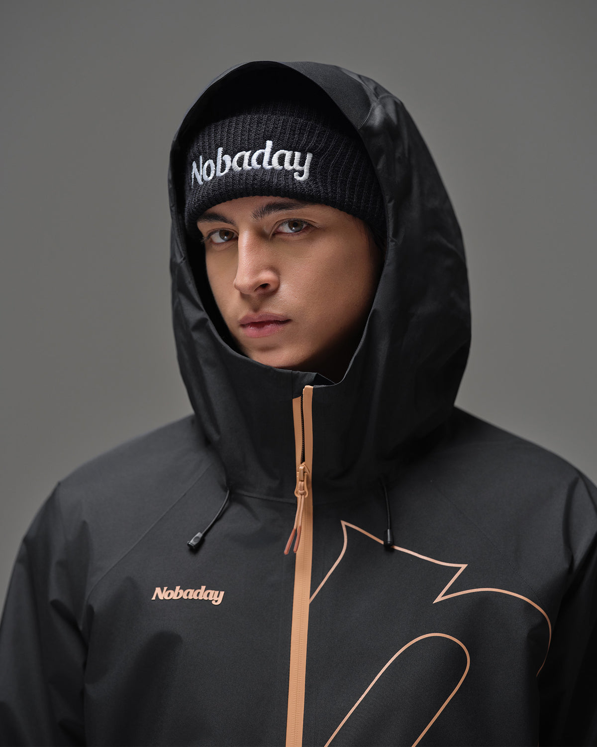 Close-up of a man wearing the hood on the Black NOBADAY Men’s Summit GORE-TEX snow jacket