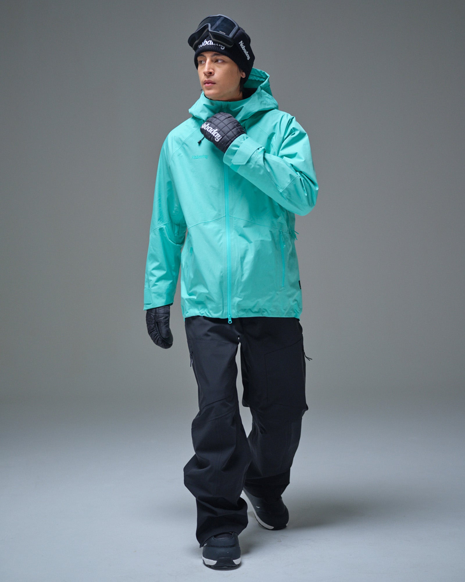 Full-body view of a man wearing the NOBADAY Men’s Summit GORE-TEX snow jacket in Nobaday Blue with black snow pants