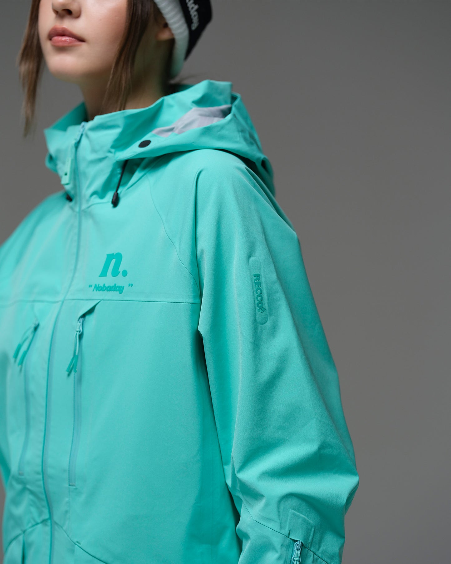 Close-up of the NOBADAY Women's ArcticStorm Freeride 3L blue snow jacket showing the hood, logo, and waterproof chest zippers