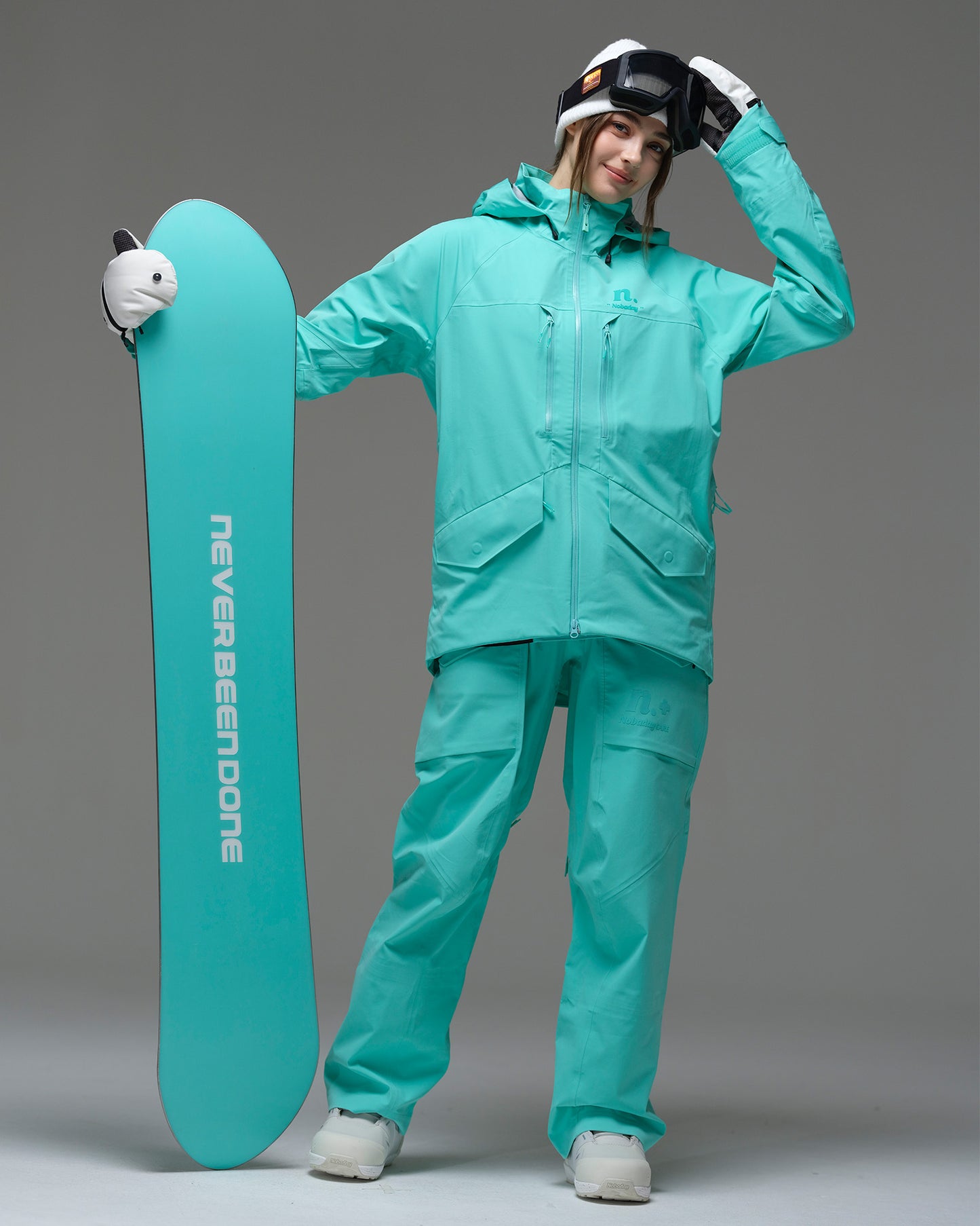 Full-body view of a snowboarder wearing the NOBADAY ArcticStorm Freeride 3L blue snow jacket with matching pants and snowboard