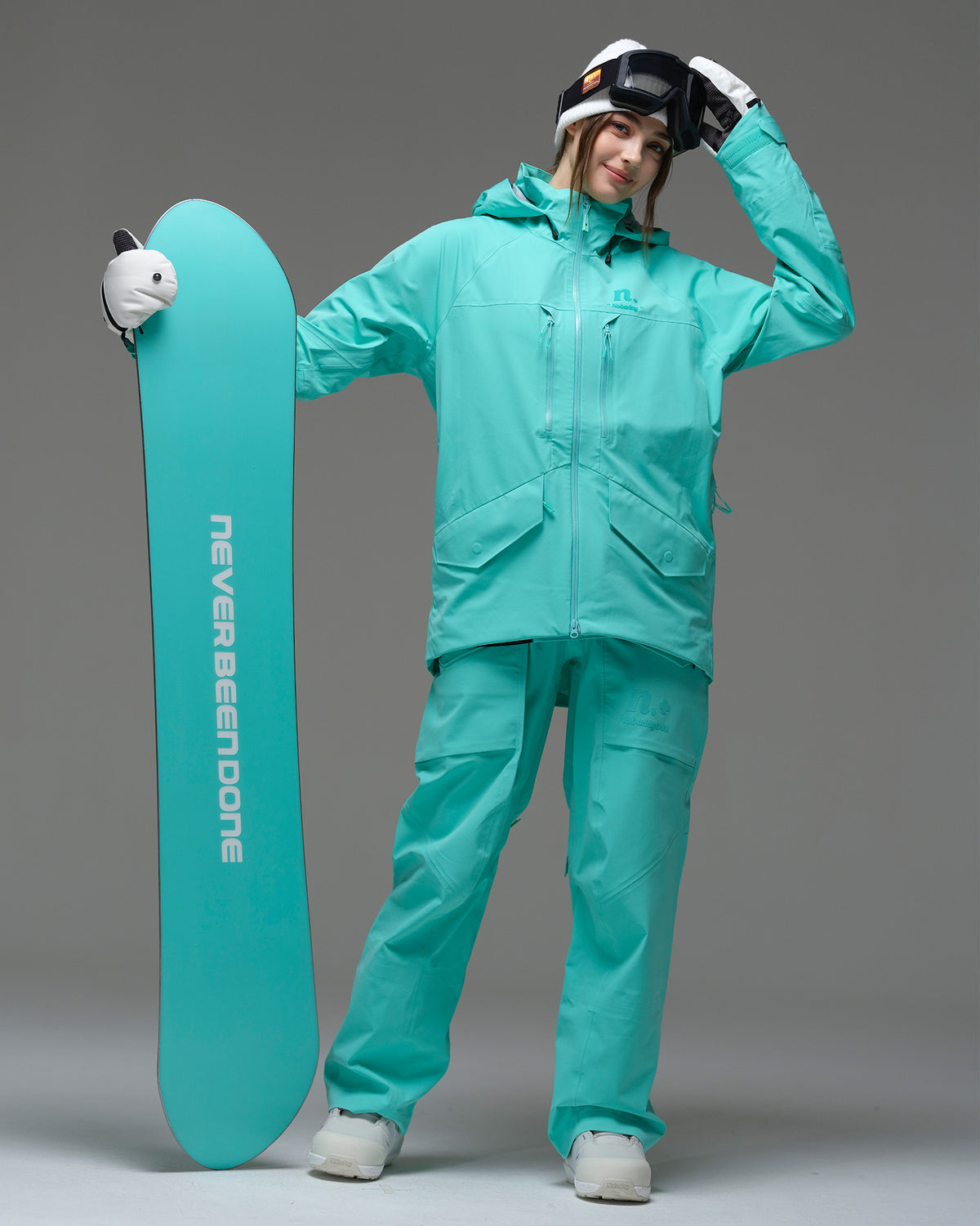 Full-body view of a snowboarder wearing the NOBADAY ArcticStorm Freeride 3L blue snow jacket with matching pants and snowboard