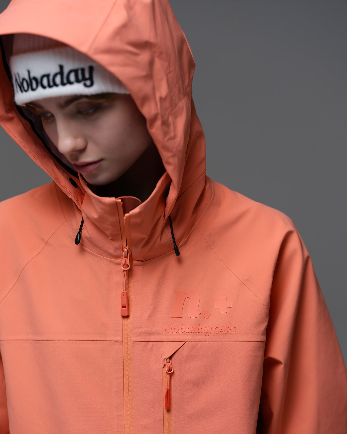 Close-up of the adjustable hood and high collar on the coral orange Nobaday Women’s ArcticStorm Freeride Zip-Up 3L Snow Jacket