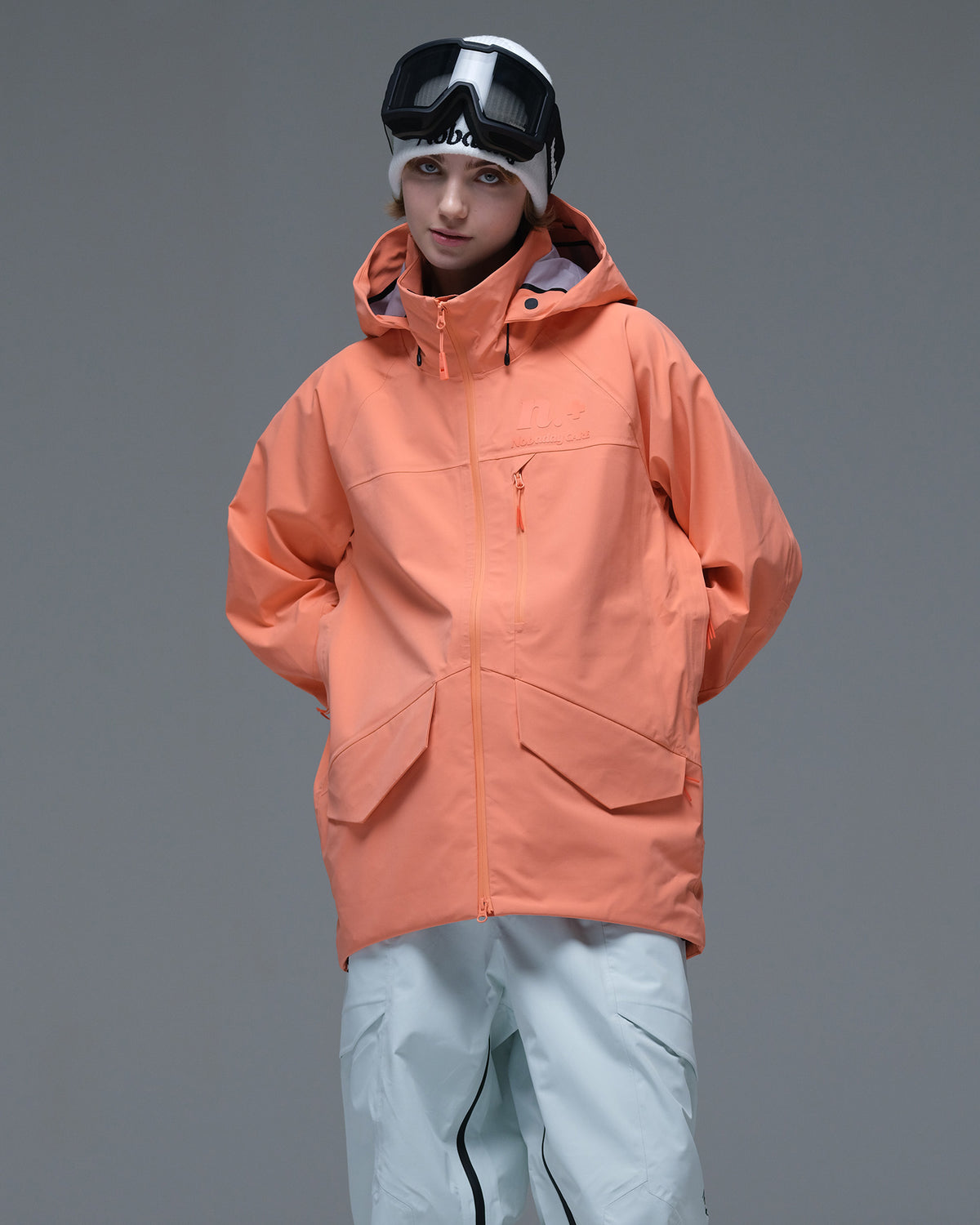 Half-body action view of a model wearing the coral orange Nobaday Women’s ArcticStorm Freeride Zip-Up 3L Snow Jacket
