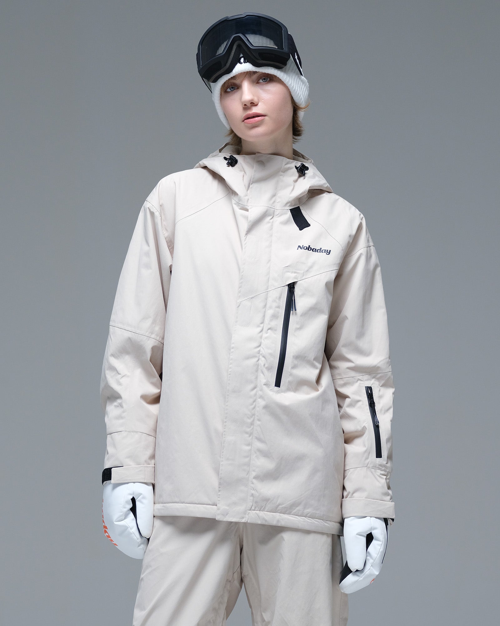 Front view of the NOBADAY Women's Baggy Insulated beige snow jacket with an adjustable hood, chest zip pocket, and relaxed fit