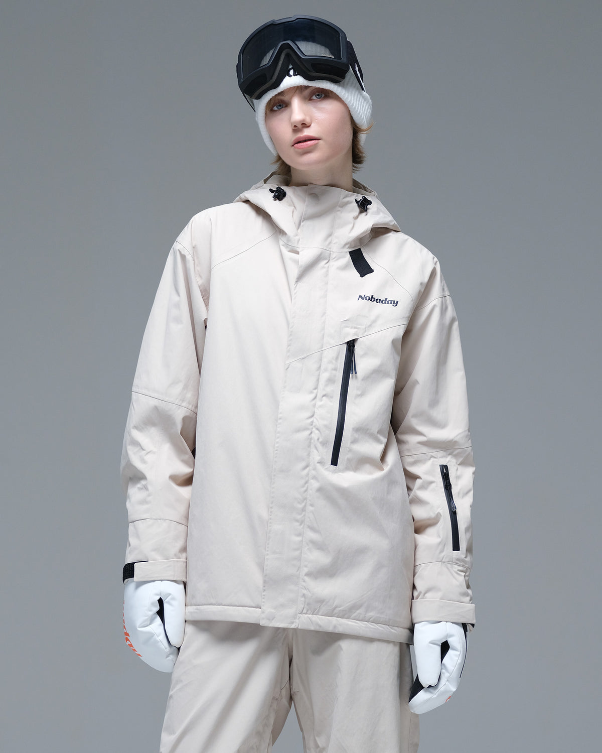 Front view of the NOBADAY Women's Baggy Insulated beige snow jacket with an adjustable hood, chest zip pocket, and relaxed fit