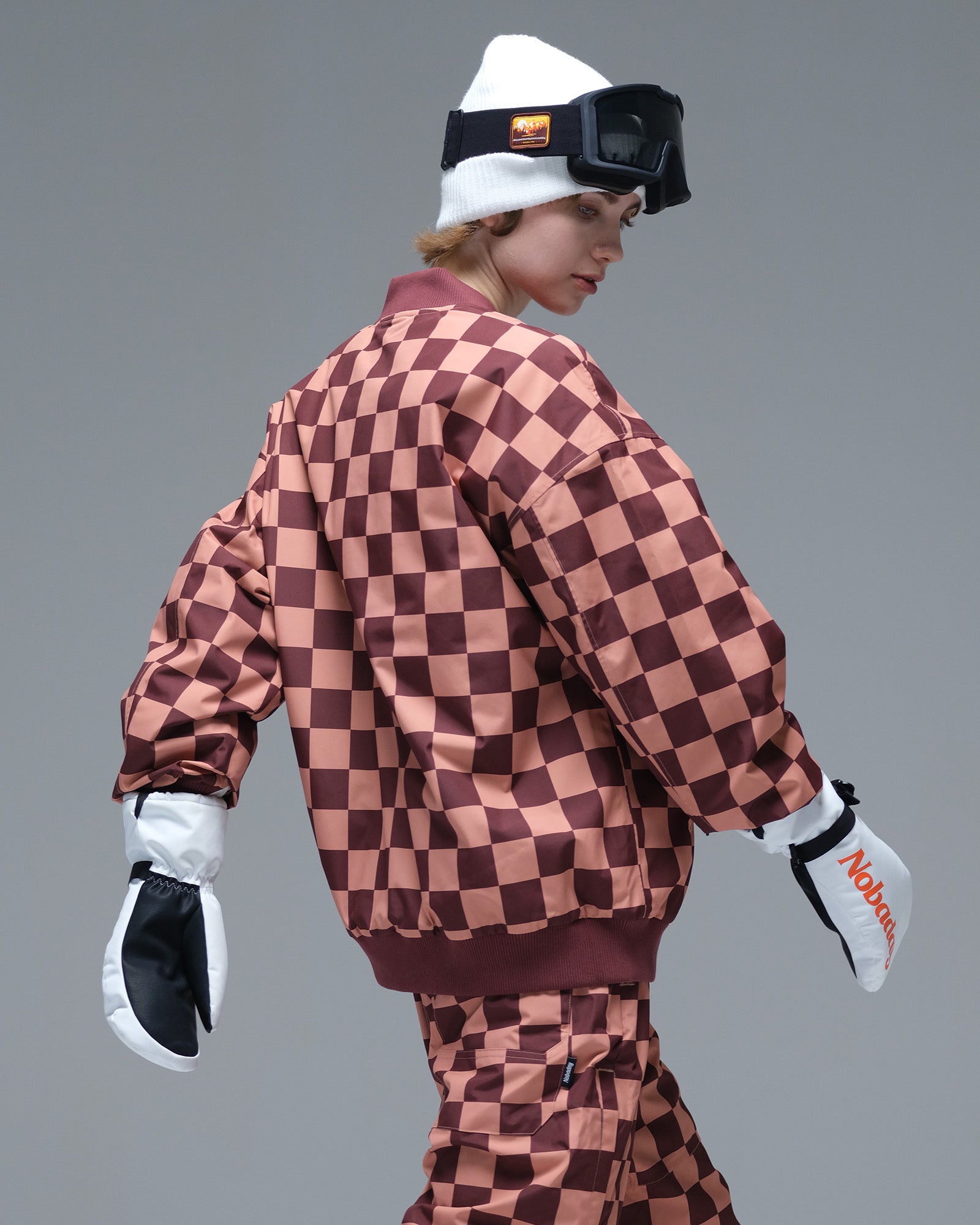 Back view of the Nobaday Women’s Baseball Insulated Snow Jacket showing its brown and pink plaid pattern and ribbed hem