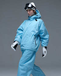 Half-body action pose of a woman wearing the NOBADAY Women's Dawn OG Insulated ice blue snow jacket with an adjustable storm hood