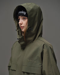 Close-up of Nobaday women's green cargo snow jacket showing oversized adjustable hood, high collar, and embroidered logo detail