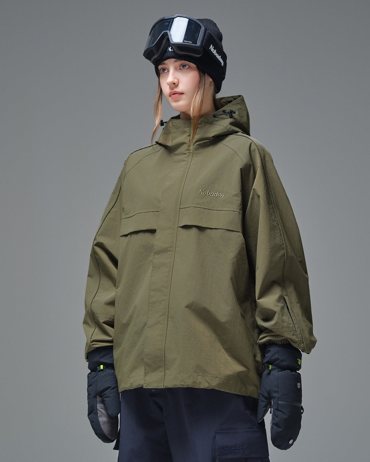 Side view of Nobaday Women's Pure Free Cargo green snow jacket with high collar, sleeve pocket, and loose snowboard fit