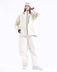 Full-body pose of a woman wearing the NOBADAY Women's Juicy 3L white snow jacket with matching white snow pants