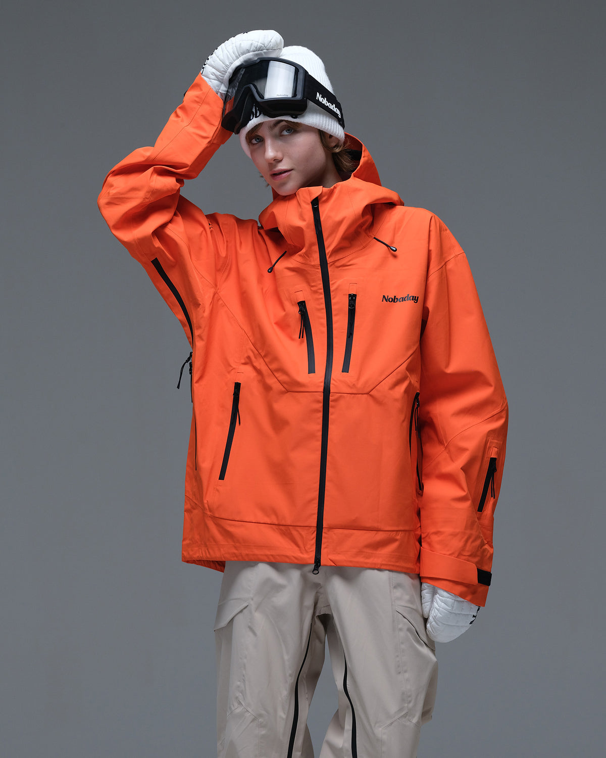 Half-body action view of a model wearing the orange Nobaday Women’s MaxExtreme Pro Zip-Up 3L Snow Jacket with black waterproof zippers