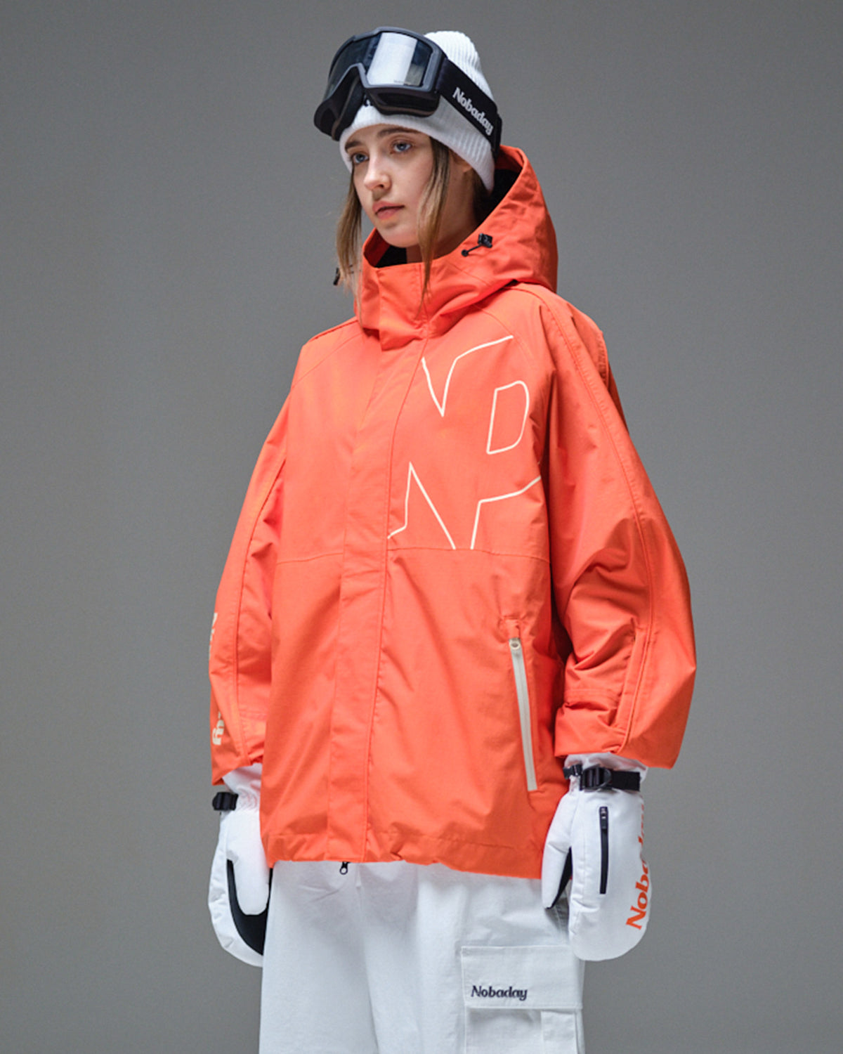 Side view of Nobaday women's orange active snow jacket with high collar, adjustable hood, sleeve pass pocket, and relaxed snowboard fit