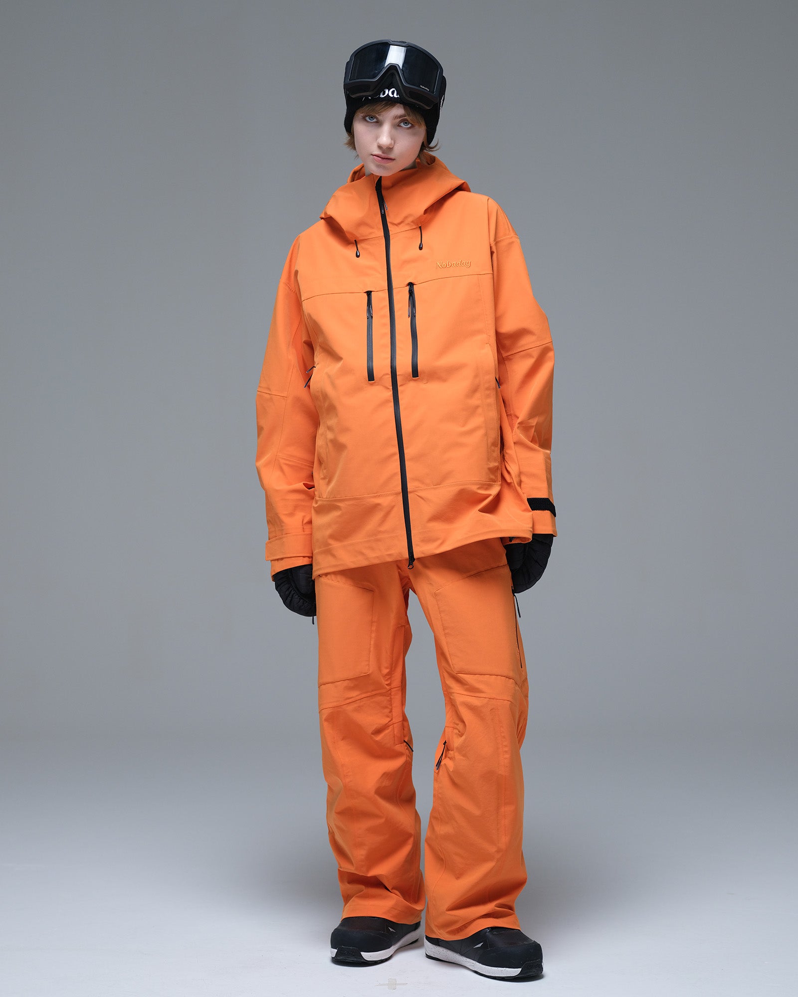 Full-body front view of the NOBADAY Women's Pure Free 3L orange waterproof snow jacket with matching snow pants