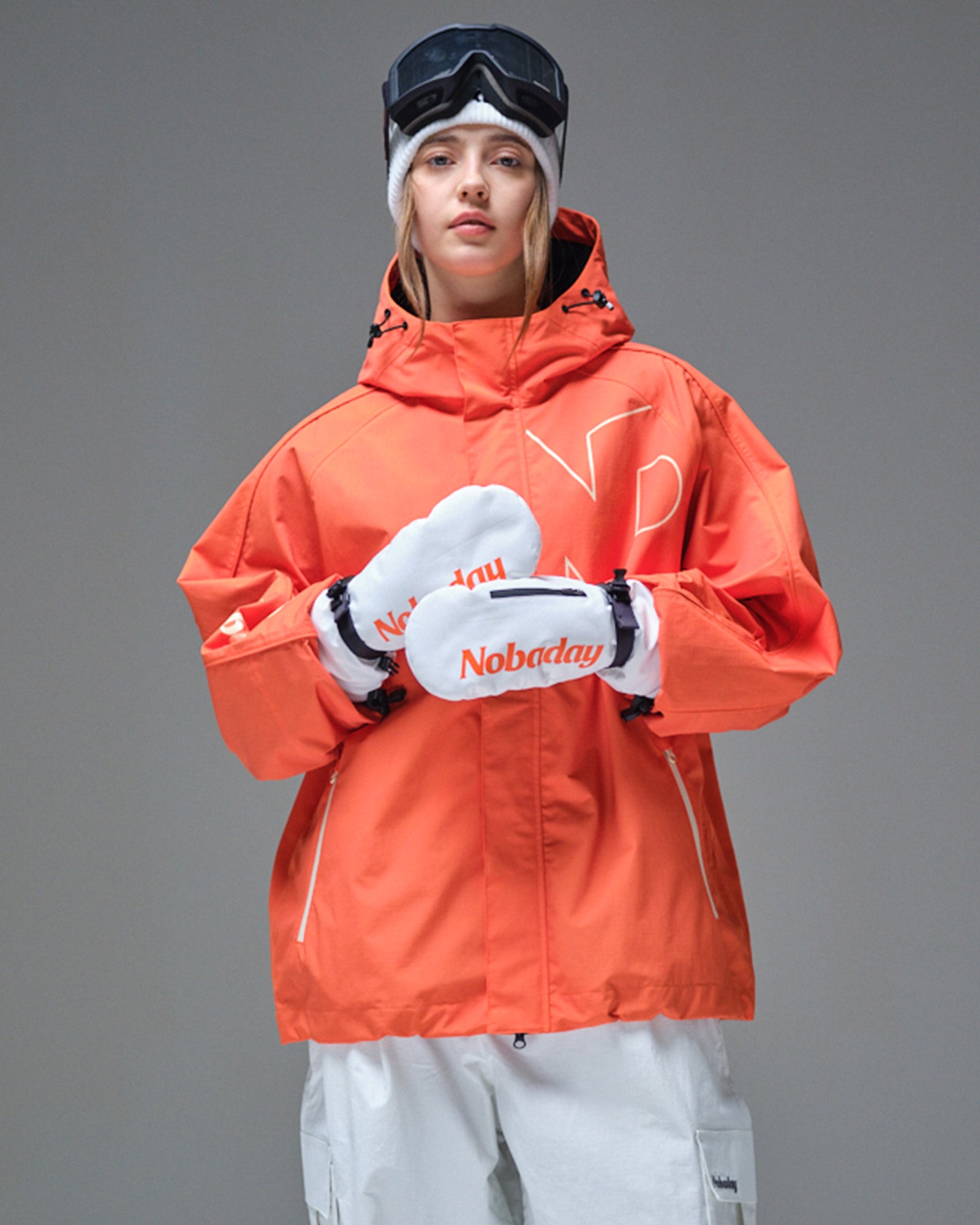 Front view of Nobaday Women's Pure Free Active orange snow jacket with storm flap, oversized sleeves, mittens, and waterproof shell