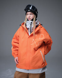Nobaday Women's Pure Free Active orange snow jacket layered over a white midlayer with goggles, oversized sleeves, and waterproof shell