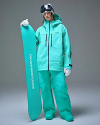 Full-body view of a woman wearing the Nobaday Pure Free Apex 3L snow jacket and matching snow pants in blue while holding a snowboard