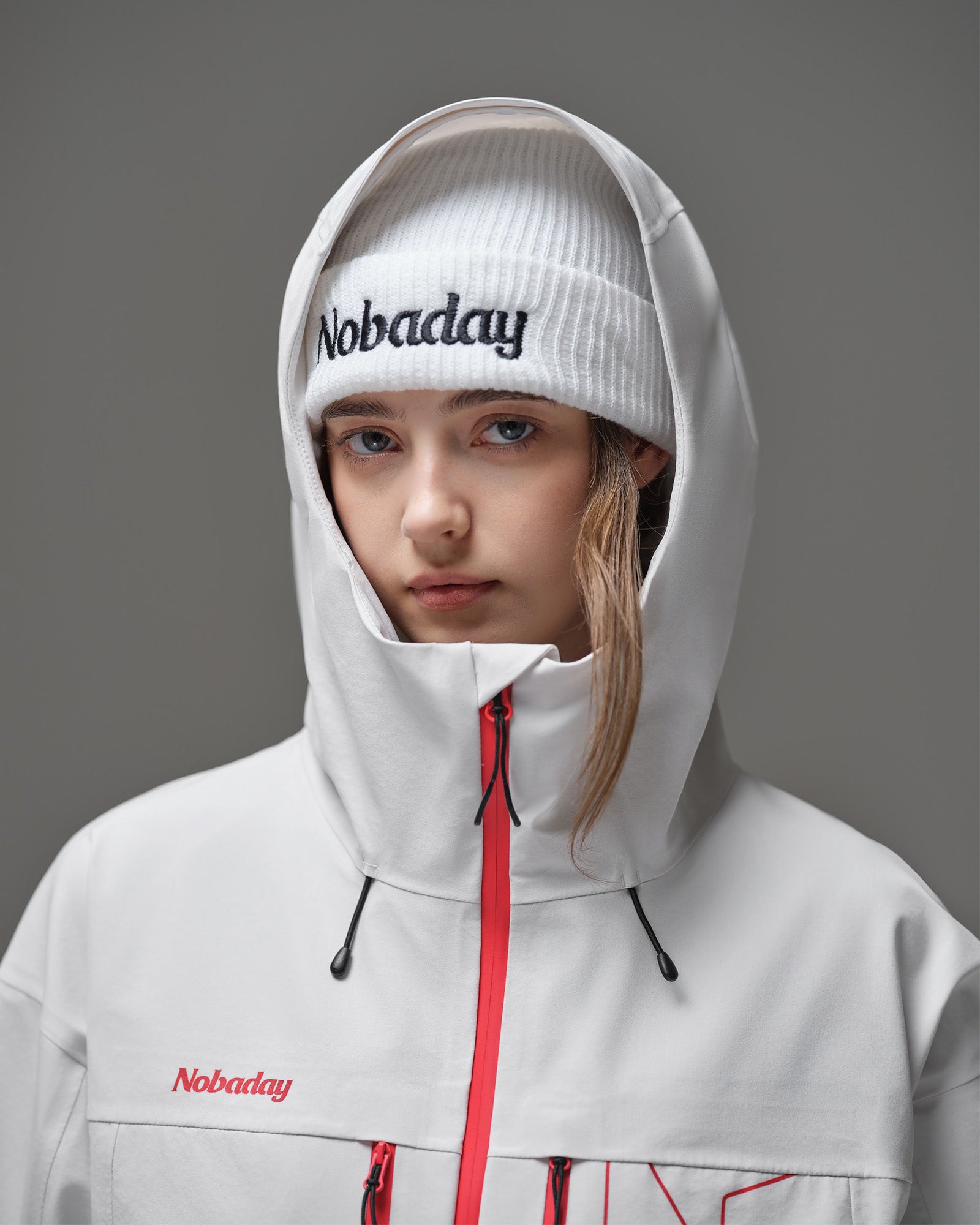 Protective hood and high collar detail on the Nobaday Women's Pure Free Apex 3L waterproof snow jacket in white