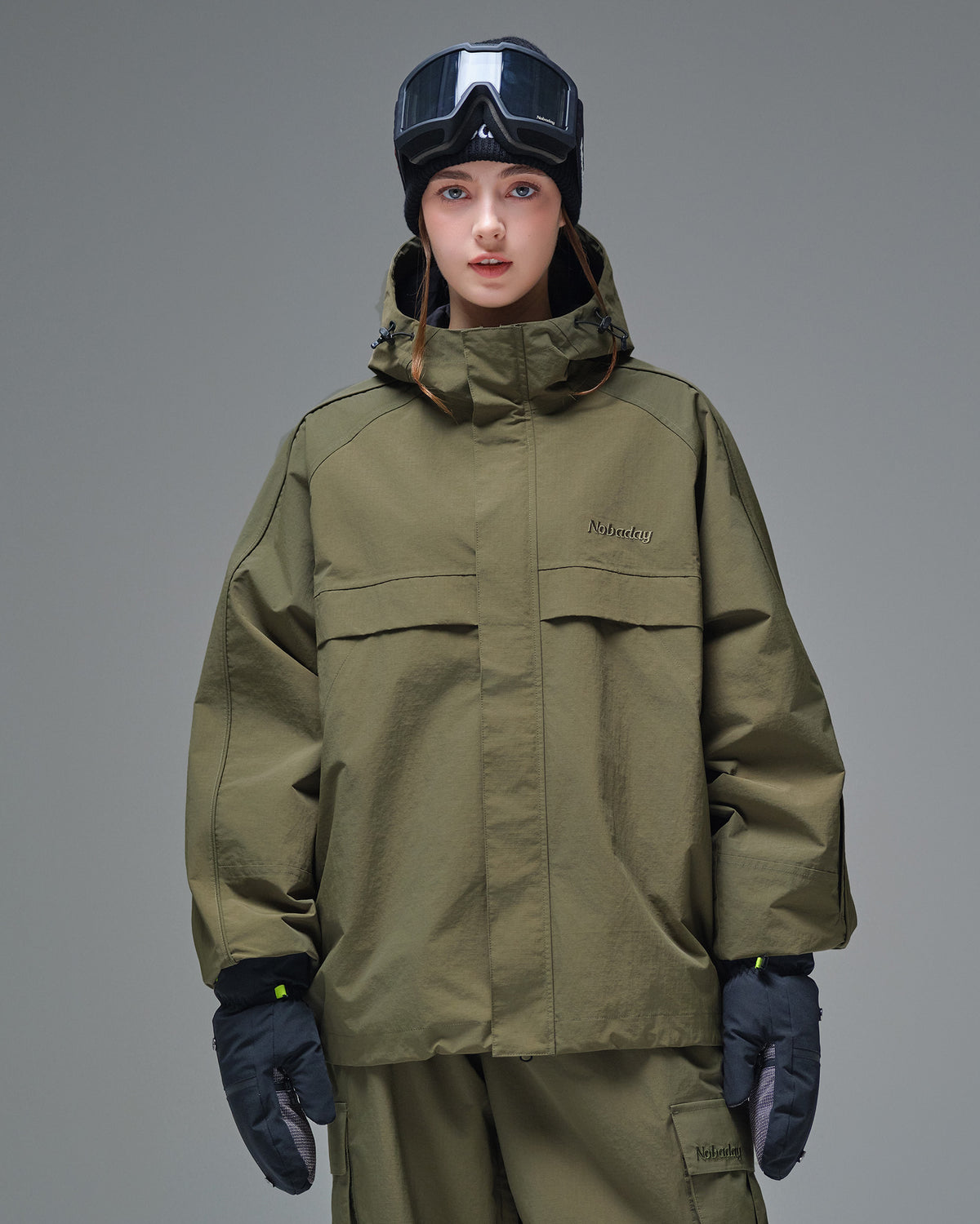 Front view of Nobaday women's green cargo snow jacket with oversized zip pockets, adjustable hood, and minimalist waterproof design