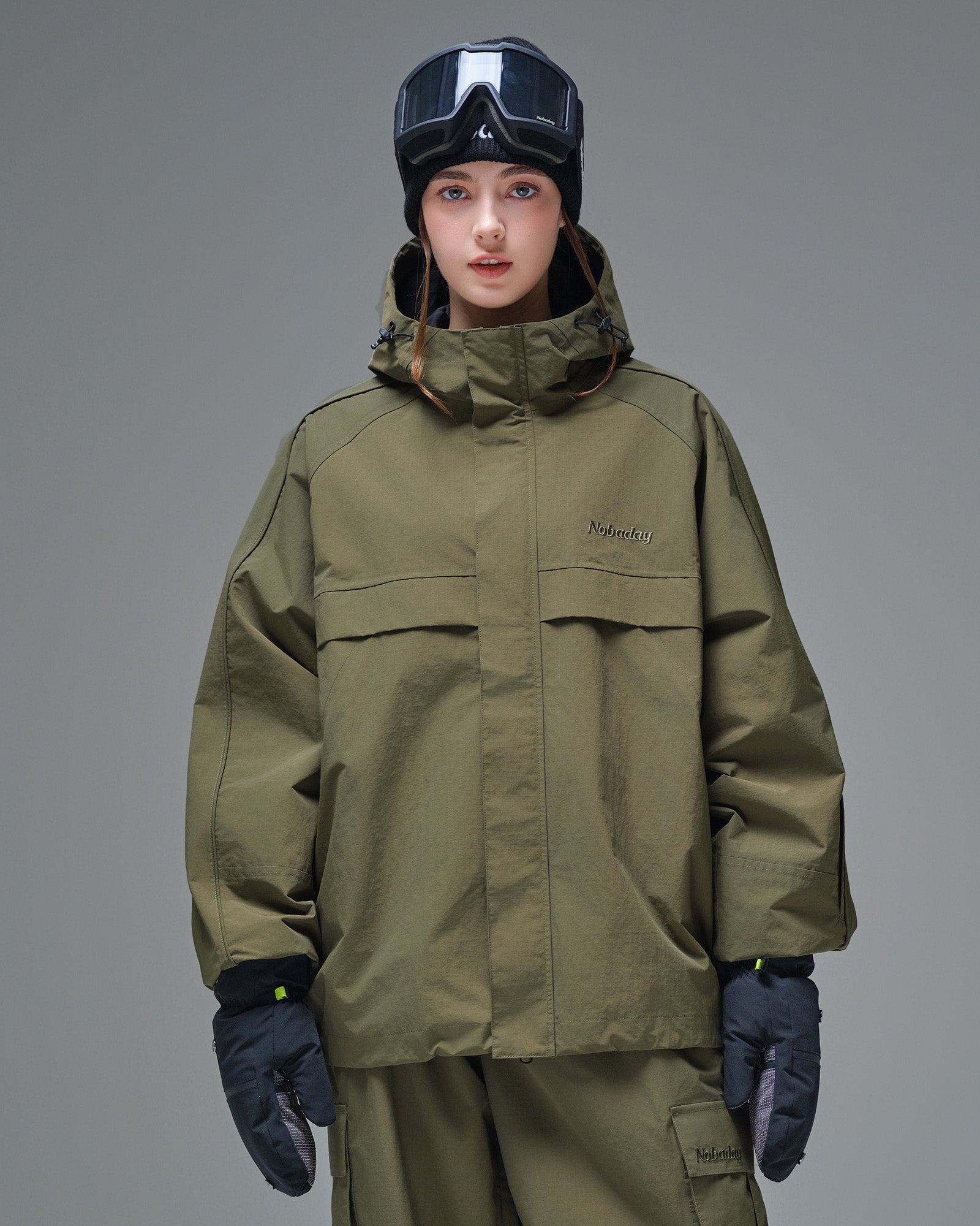 Front view of Nobaday women's green cargo snow jacket with oversized zip pockets, adjustable hood, and minimalist waterproof design