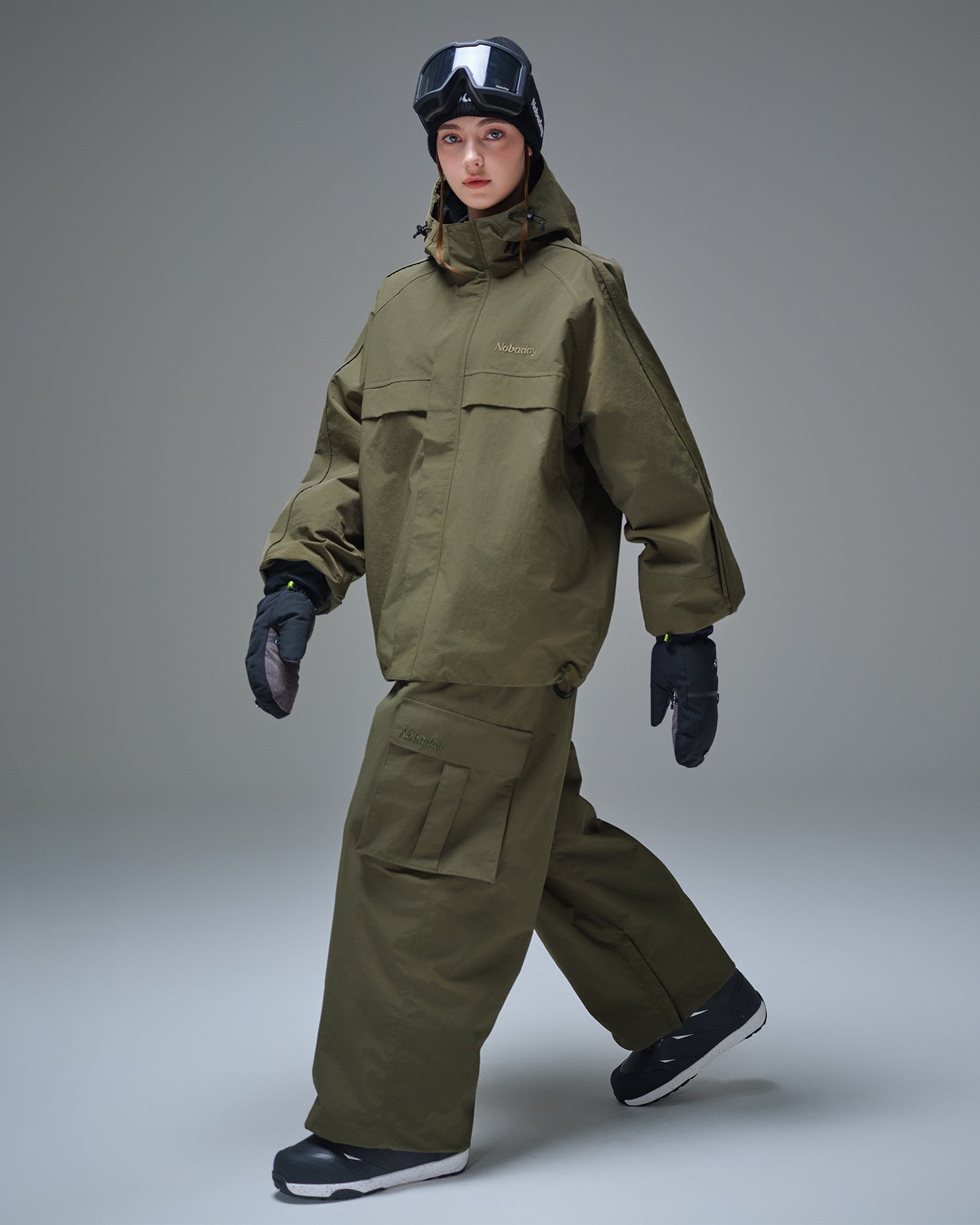 Full body front view of Nobaday women's green cargo snow jacket with oversized pockets, adjustable hood, and waterproof snowboard-ready shell