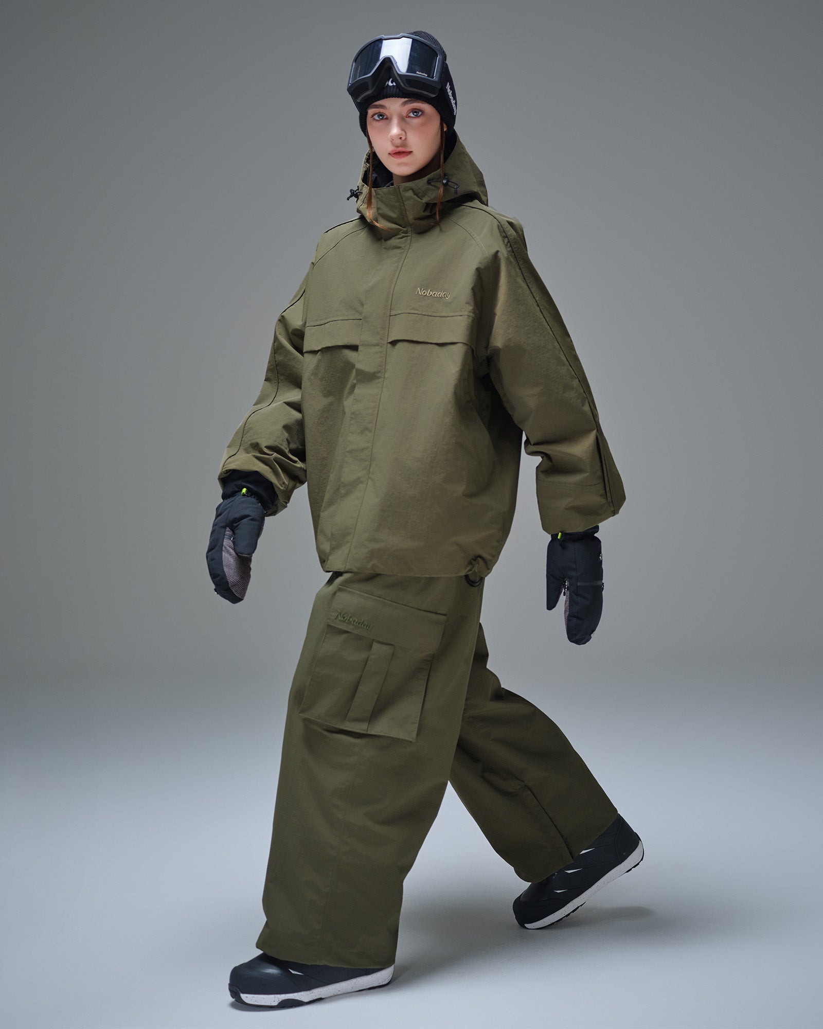 Full body front view of Nobaday women's green cargo snow jacket with oversized pockets, adjustable hood, and waterproof snowboard-ready shell