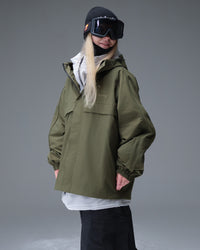 Nobaday Women's Pure Free Cargo green snow jacket layered over a white midlayer with goggles, roomy fit, and waterproof shell