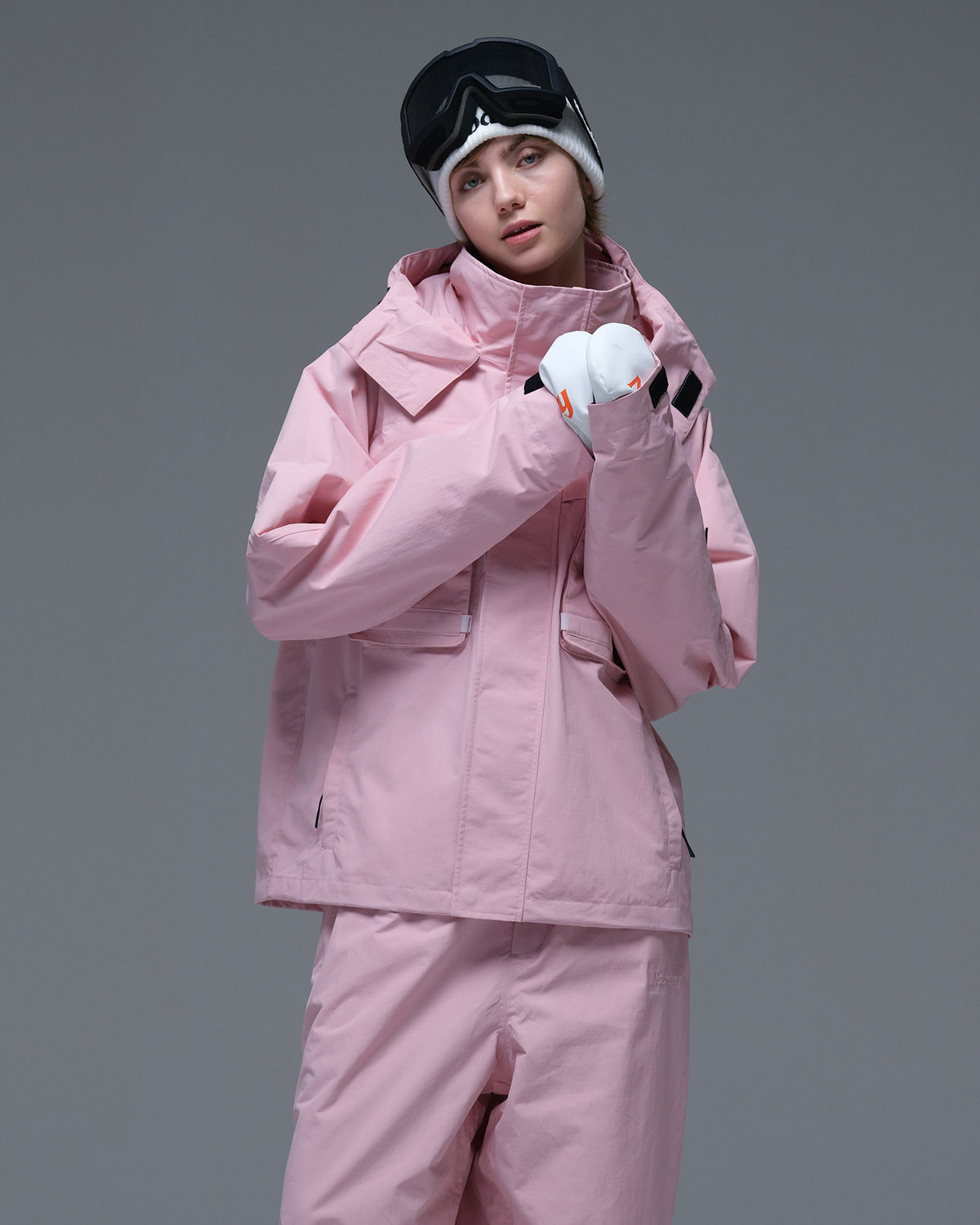 Half-body view of a model wearing the pink Nobaday Women’s Pure Free Drift Snow Jacket with front utility pockets