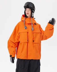 Half-body pose of a woman wearing the NOBADAY Women's Pure Free Freestyle orange snow jacket with oversized utility pockets