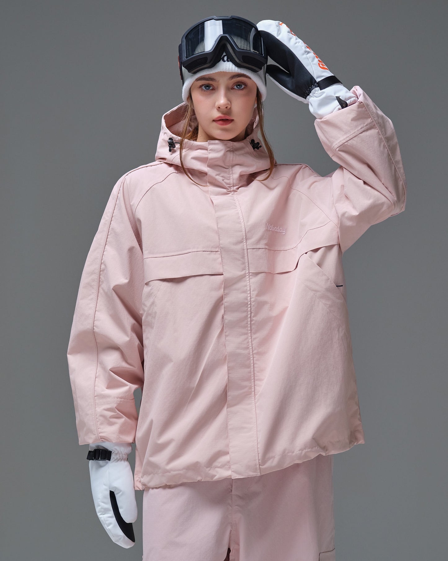Front view of a woman wearing the Nobaday Women's Pure Free Snow Jacket in pink with a high collar and hood
