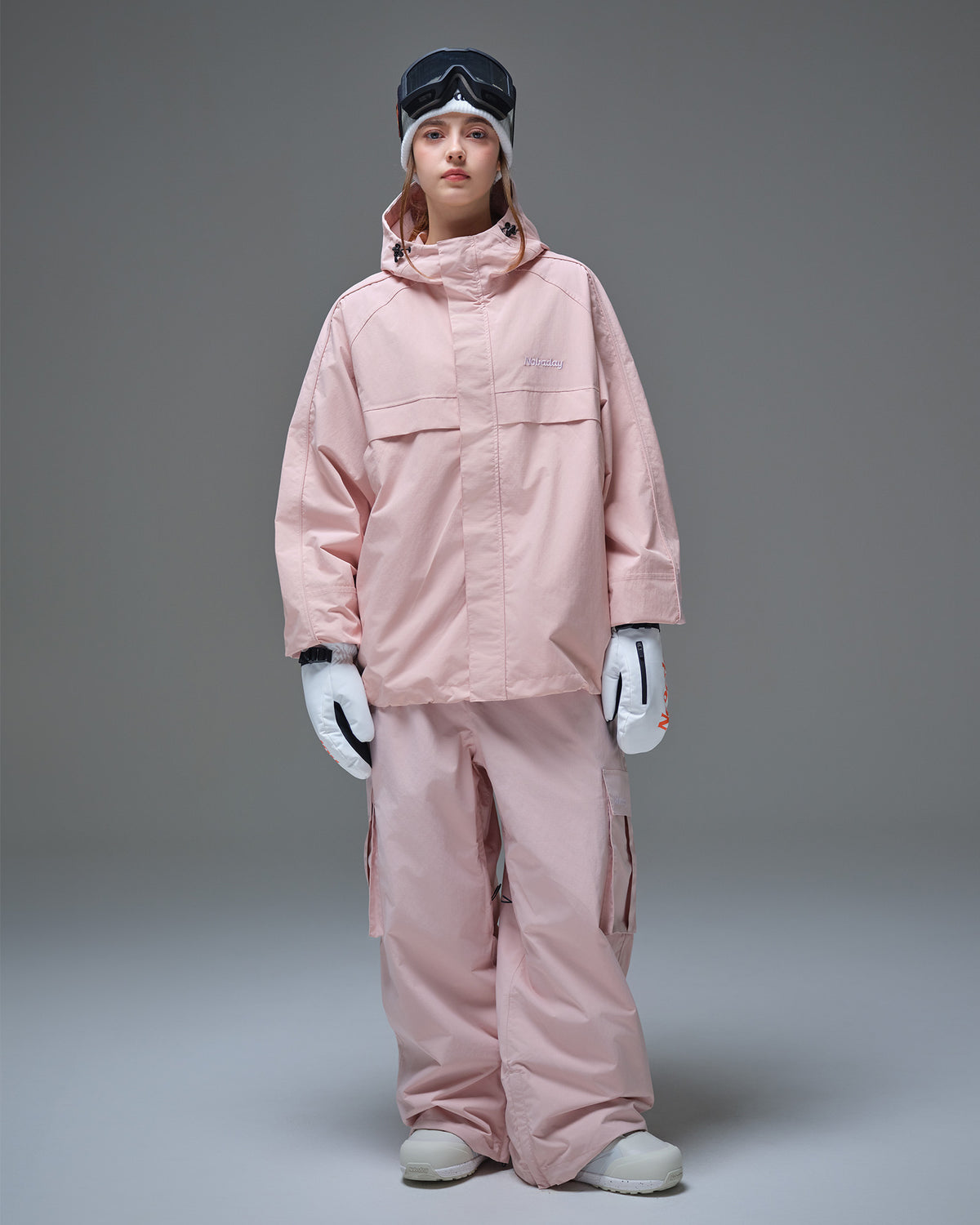 Front full-body view of a woman wearing the Nobaday Women's Pure Free Snow Jacket and matching snow pants in pink