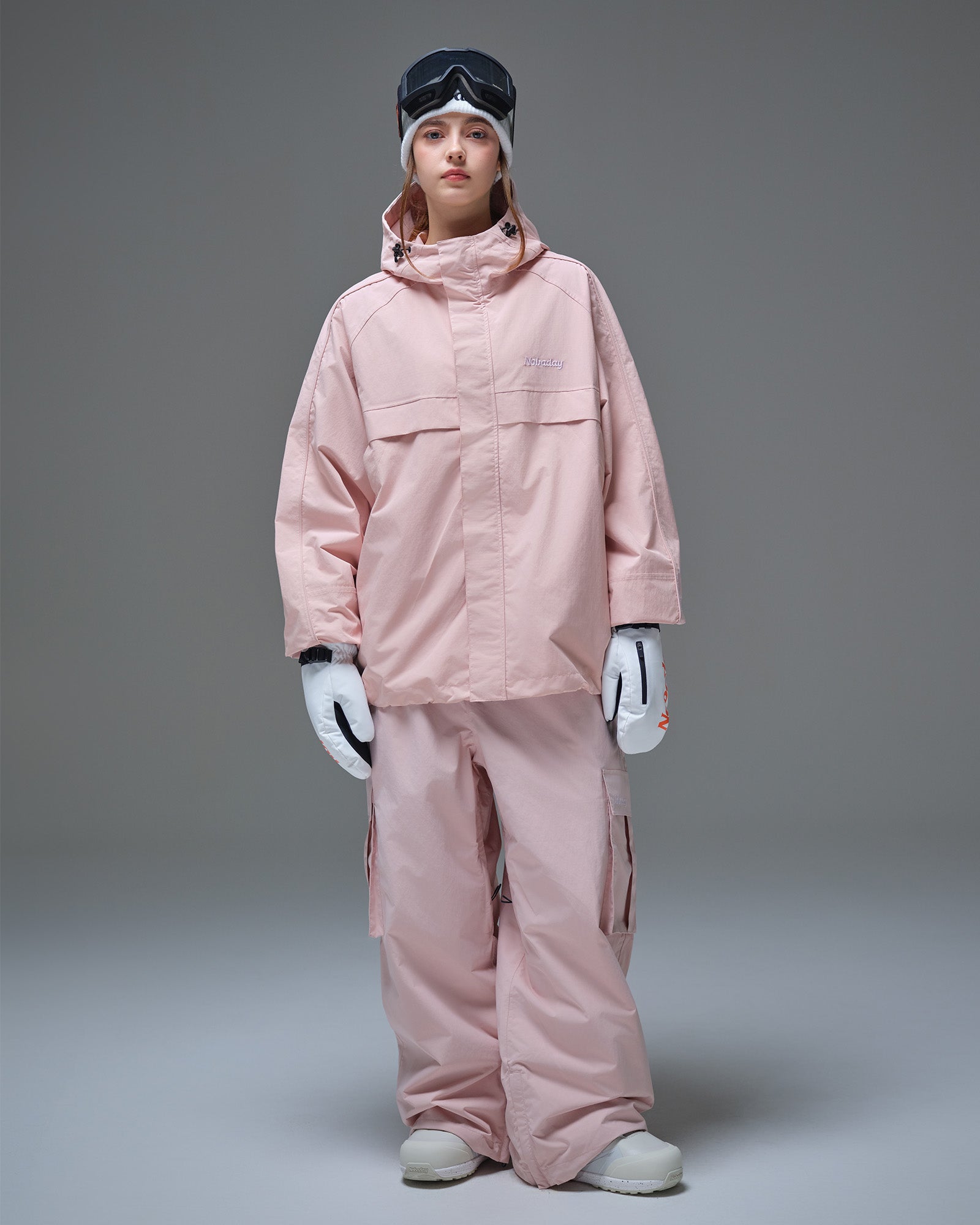 Front full-body view of a woman wearing the Nobaday Women's Pure Free Snow Jacket and matching snow pants in pink