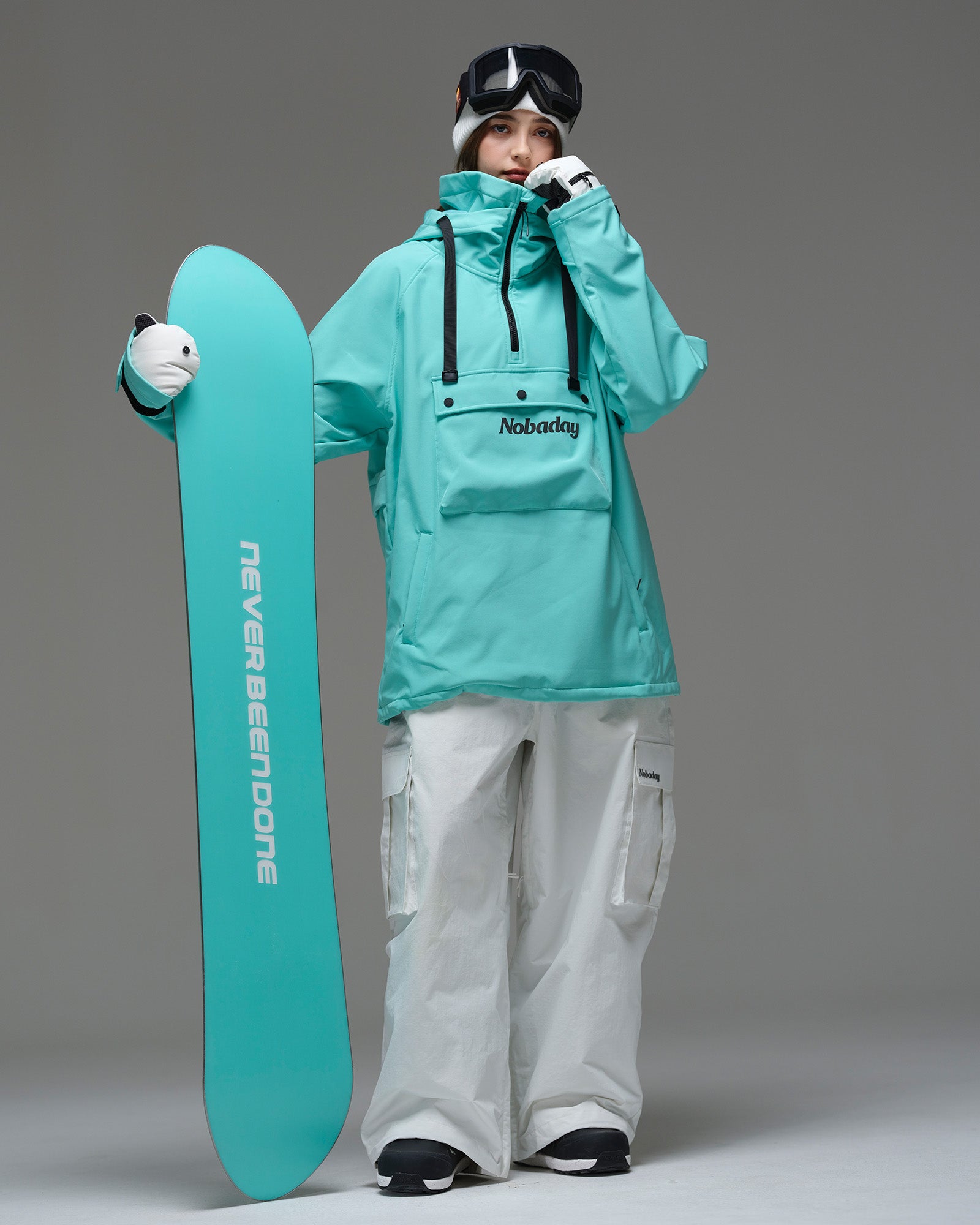 Female model wearing Nobaday Women's Pure Free Waterproof Fleece Hoodie Blue while holding a snowboard, waterproof softshell fleece ski hoodie